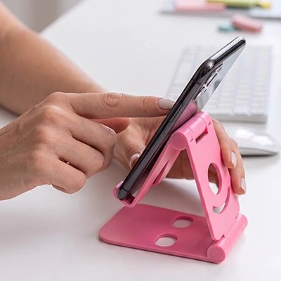 Main de femme qui utilise Support telephone rose